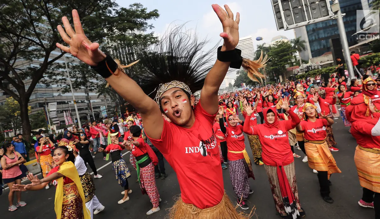 Seorang penari diikuti ribuan peserta membawakan Tari Yamko dari Papua saat CFD di Senayan, Jakarta, Minggu (12/8). Kegiatan ini digelar menyambut HUT Ke-73 RI dan Asian Games 2018. (Liputan6.com/Fery Pradolo)