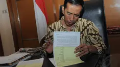 Jokowi menandatangi sejumlah surat dan berkas di ruang kerjanya di Balai Kota, Jakarta, Rabu (17/9/14). (Liputan6.com/Herman Zakharia)