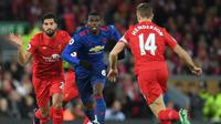 Gelandang Manchester United, Paul Pogba (tengah), mendapat pengawalan dari dua pemain Liverpool pada laga Premier League di Anfield, Senin (17/10/2016). (AFP/Paul Ellis)