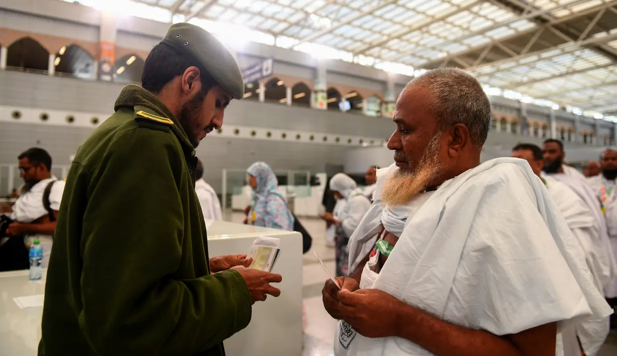 Seorang petugas melakukan pemeriksaan paspor calon jemaah haji di Bandara King abdul Aziz, Jeddah, Arab Saudi, Minggu (7/7/2019). Menunaikan ibadah haji merupakan rukun islam ke-5 dan dianggap pondasi wajib bagi orang-orang beriman yang mampu dan merupakan dasar dari kehidupan Muslim. (Amer HILABI/A