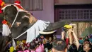 Gajah berkostum sinterklas memberikan hadiah kepada para siswa saat perayaan Natal di sekolah Jirasartwitthaya, Provinsi Ayutthaya, Thailand, Senin (23/12/2019). Kendati warga Thailand sebagian besar beragama Buddha, perayaan Natal adalah hal biasa. (Mladen ANTONOV/AFP)