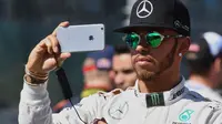 Pembalap F1 dari tim  Mercedes, Lewis Hamilton berselfie saat Formula One Grand Prix di Melbourne, Australia (20/3/16). Lewis Hamilton memiliki 2 juta followers di media sosial Instagram dengan 1887 foto. (REUTERS/Brandon Malone)