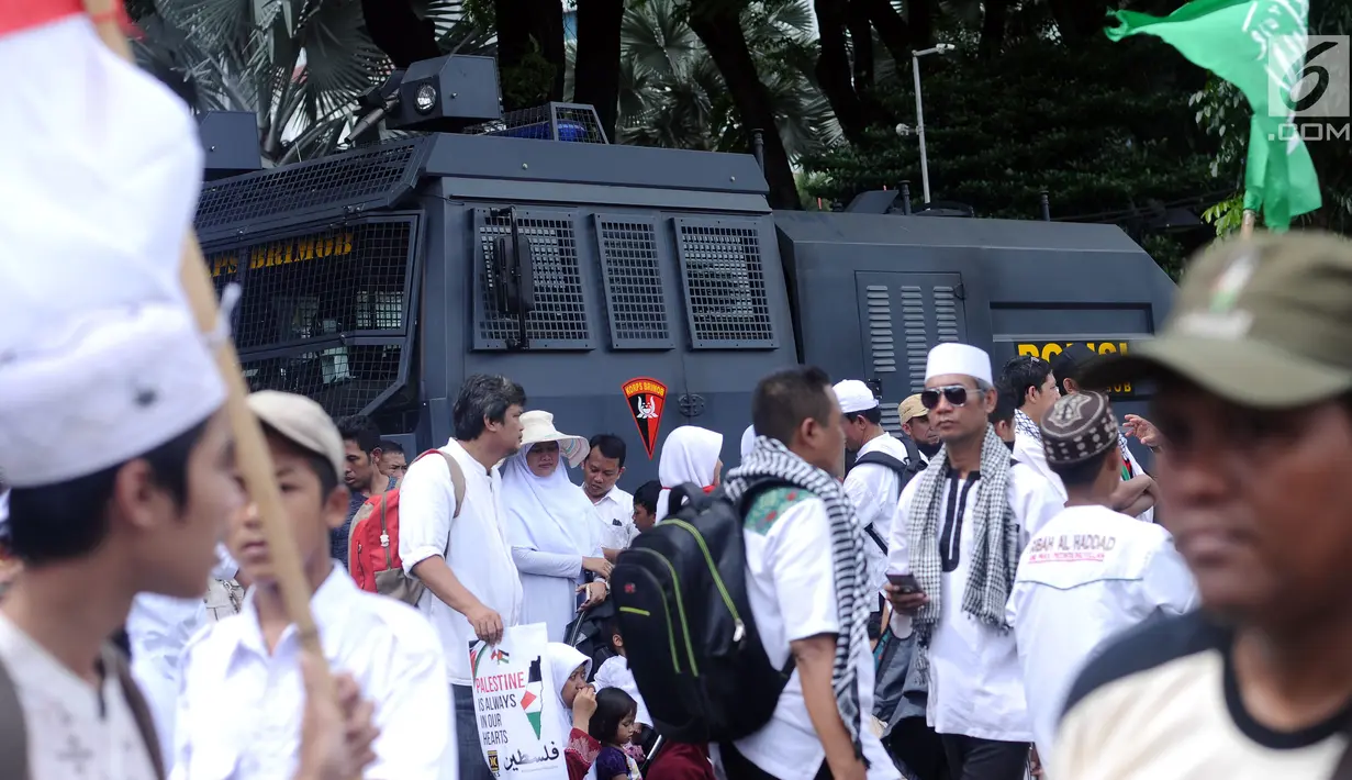 Massa berkumpul di depan kendaraan taktis polisi saat aksi dukungan bagi Palestina di depan Kedubes AS, Jakarta, Minggu (10/12). Mereka memprotes keputusan Presiden Trump yang mengakui Yerusalem jadi Ibu Kota Israel. (Liputan6.com/Helmi Fithriansyah)