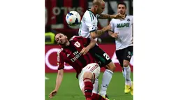 Penyerang AC Milan, Giampaolo Pazzini (kiri) terjatuh saat berebut bola dengan pemain belakang Sassuolo, Paolo Cannavaro, saat berlaga di Stadion San Siro, (18/5/2014). (AFP PHOTO/Giuseppe Cacace)