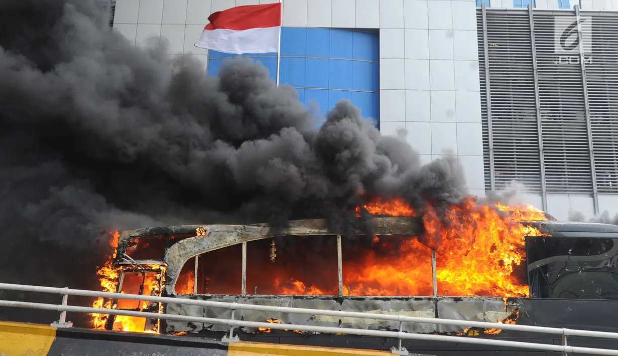 Asap terlihat dari api yang membakar bus polisi di dekat Flyover Slipi, Palmerah, Jakarta Barat, Rabu (22/5/2019). Belum diketahui penyebab terbakarnya dua bus yang terparkir bersama bus polisi lainnya dilokasi tersebut. (merdeka.com/Arie Basuki)