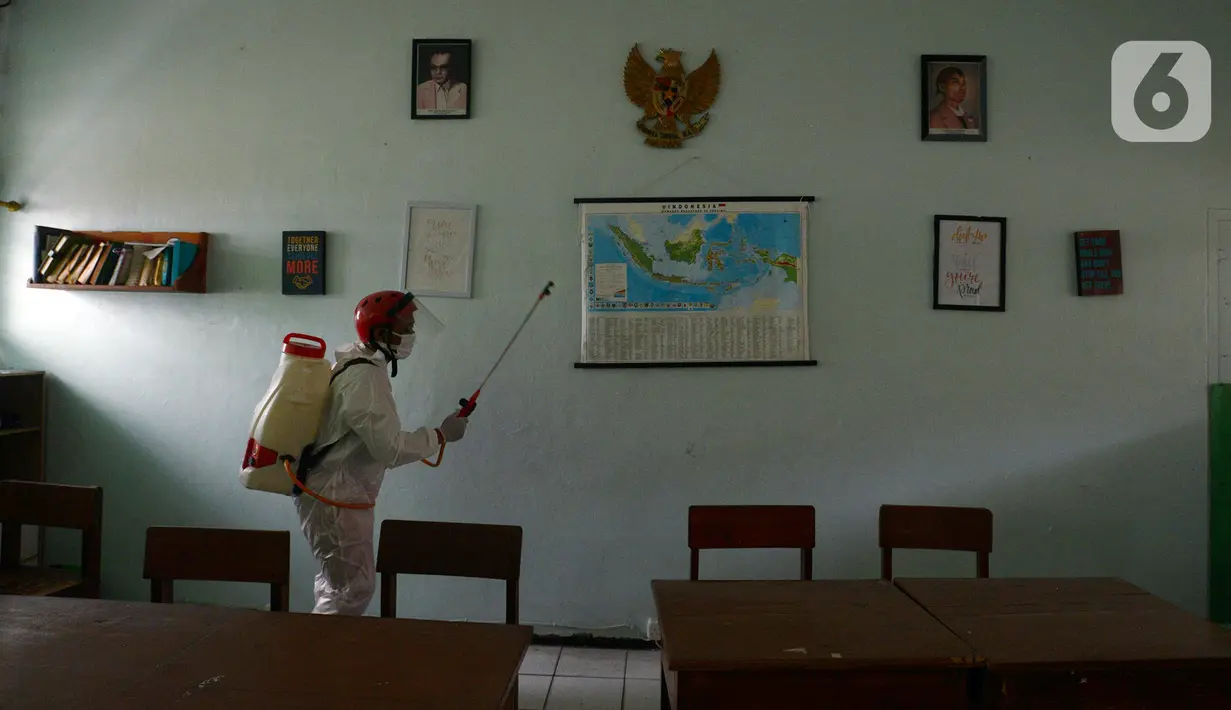 Petugas Palang Merah Indonesia (PMI) menyemprotkan cairan disinfektan di SMA 70 Jakarta, Kamis (27/1/2022). Pemprov DKI Jakarta mencatat ada 90 sekolah ditutup sementara akibat ditemukannya kasus COVID-19 varian Omicron yang tersebar di lima kota administrasi DKI Jakarta. (merdeka.com/Imam Buhori)