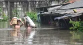 Warga menyelamatkan sagu miliknya saat banjir menggenangi kawasan Kampung Cantiga, Petir, Cipondoh, Kota Tangerang, Banten, Selasa (8/7/2025). (merdeka.com/Arie Basuki)