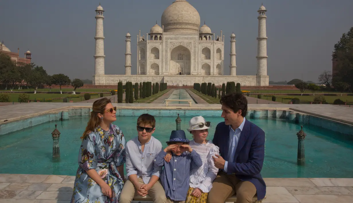 PM Kanada Justin Trudeau bersama sang istri, Sophie Gregoire Trudeau serta tiga anaknya berpose di depan Taj Mahal di sela-sela kunjungan ke India, Minggu (18/2). Ini adalah kunjungan pertama Tredeau ke India sejak menjabat pada 2015. (AP/Manish Swarup)