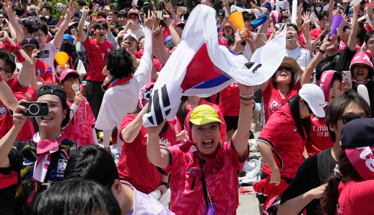 Para penggemar sepak bola Korea Selatan merayakan kemenangan setelah Korea Selatan mengalahkan Republik Ceko dalam pertandingan Grup A Piala Dunia di Meksiko, di sebuah tempat menonton umum di Seoul, Korea Selatan, Jumat 12 Juni 2026. (AP Photo/Ahn Young-joon)