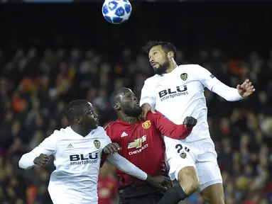 Romelu Lukaku berduel dengan bek Valencia, Ezequiel Garay pada laga terakhir grup H Liga Champions yang berlangsung di stadion Mestalla, Valencia, Rabu (13/12). Manchester United kalah 1-2 atas Valencia. (AFP/Jose Jordan)