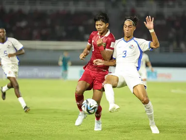 Pemain Timnas Indonesia U-17 Arkhan Kaka Purwanto berebut bola dengan pemain Timnas Panama U-17 Martín Krug pada partai kedua Grup A Piala Dunia U-17 2023 di Gelora Bung Tomo, Senin (13/11/2023). (Doc. LOC WCU17/NFL)