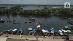 Sejumlah nelayan bersiap untuk melarung replika kapal berisi sesaji di Pantai Tarumajaya, Kabupaten Bekasi, Jawa Barat, Jumat (28/1/2022). Ritual ini diikuti sebanyak 40 kapal nelayan dari enam Muara. (Liputan6.com/Herman Zakharia)