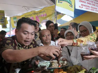 Plt Gubernur DKI Jakarta, Djarot Saiful Hidayat saat membeli jajanan takjil di pasar Benhil, Jakarta, Jumat (2/6). Djarot meninjau pasar takjil Benhil serta membeli aneka makanan takjil tradisional. (Liputan6.com/Yoppy Renato)