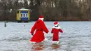 Puluhan anggota klub renang es "Berliner Seehunde" merayakan Natal dengan berenang di danau Orankesee, Berlin (25/12/2014). Dua anggota klub bersiap berenang di danau Orankesee, Berlin. (REUTERS/Fabrizio Bensch)