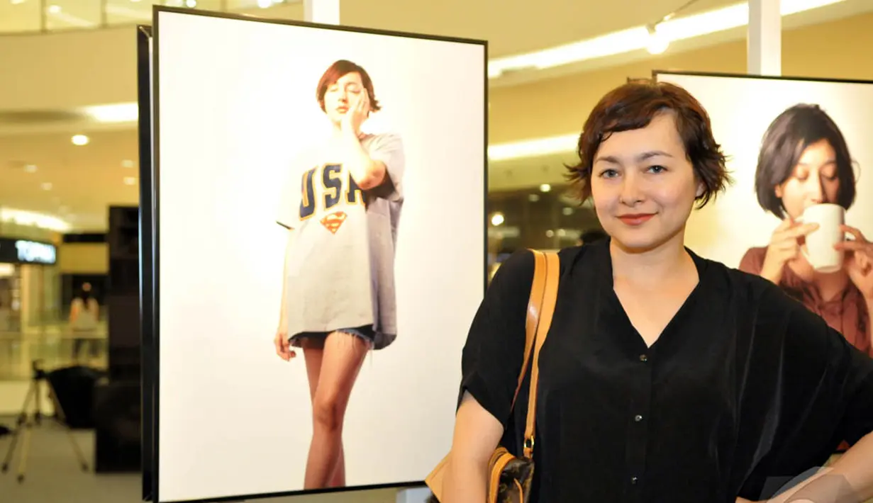 Dewi Rezer narsis di samping foto dirinya saat hadiri pameran tunggal Jerry Aurum, Senayan City, Jakarta, Rabu (17/9/2014) (Liputan6.com/Panji Diksana)