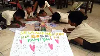 Puluhan siswa SDK di Desa Pabian, Kecamatan Kota Sumenep, Jawa Timur, memiliki cara tersendiri untuk menyampaikan ucapan selamat kepada Kahiyang Ayu-Bobby Nasution. (Liputan6.com/Mohamad Fahrul)