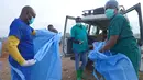 Seorang petugas kesehatan menyemprotkan disinfektan ke tubuh rekannya setelah mengikuti prosesi pemakaman seorang anak berusia 3 tahun yang meninggal akibat Ebola, di Bunia, Provinsi Ituri, Kongo bagian timur, Selasa, 18 Agustus 2026. (Foto AP/Dieudonne Dirole)