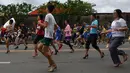 Antusias peserta berlari menggunakan sepatu high heels saat acara "Tour De Takong" di Marikina, Manila, Filipina, 26 November 2016. Balap lari itu bagian dari festival sepatu tahunan di wilayah yang dikenal sebagai ibu kota sepatu. (REUTERS/Ezra Acayan)