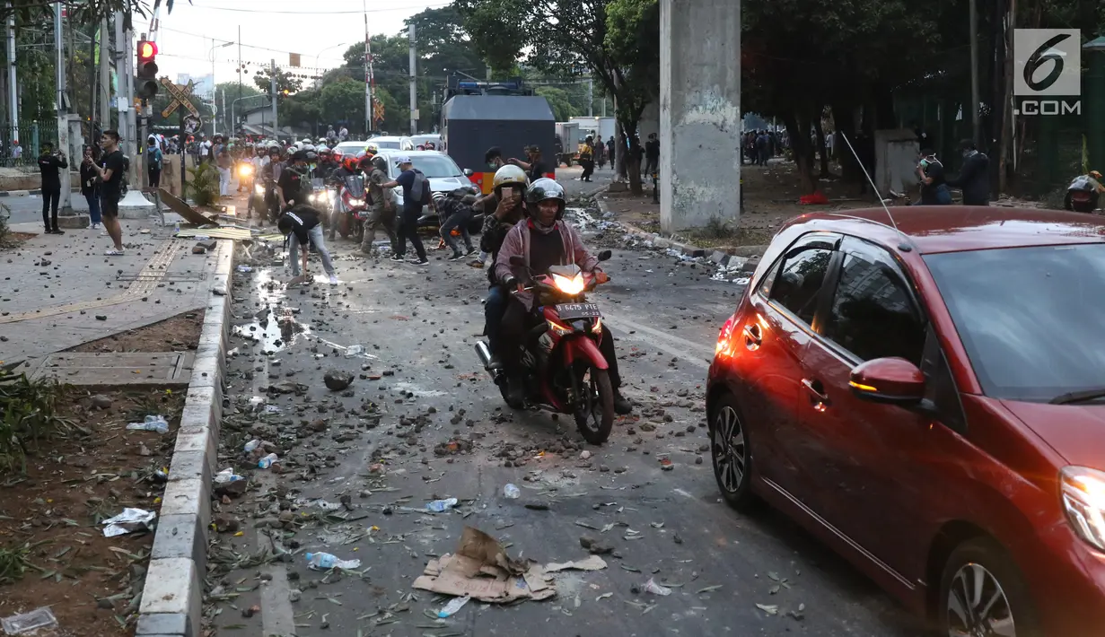 Kendaraan melintasi jalan di sekitar Stasiun Palmerah, Jakarta Barat, Senin (30/9/2019). Jalur di kawasan itu telah dibuka, namun kendaraan harus berhati-hati karena banyaknya batu sisa bentrokan massa di belakang gedung DPR yang berakhir ricuh. (Liputan6.com/Angga Yuniar)
