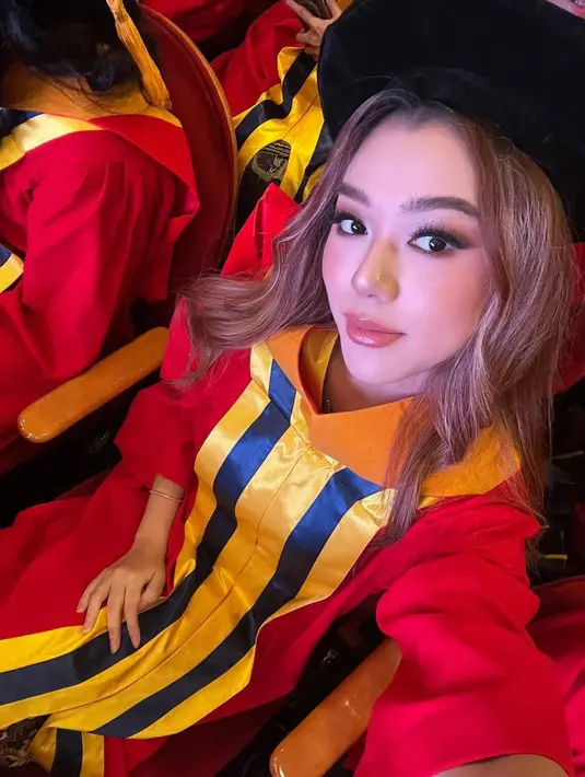 Potret Gabriella Ekaputri pakai wisuda dan toga wisuda lengkap. Ini adalah potret Gaby ketika wisuda tengah berlangsung dan menantikan namanya dipanggil. Kenakan jubah wisuda dan toga adalah yang dinantikan oleh mahasiswa semester akhir, begitu juga dengan Gabriella Ekaputri. Kerja kerasnya terbayar, keluarga dan sahabat Gaby bangga atas pencapaiannya. (Liputan6.com/IG/@gabriellaekaputri)