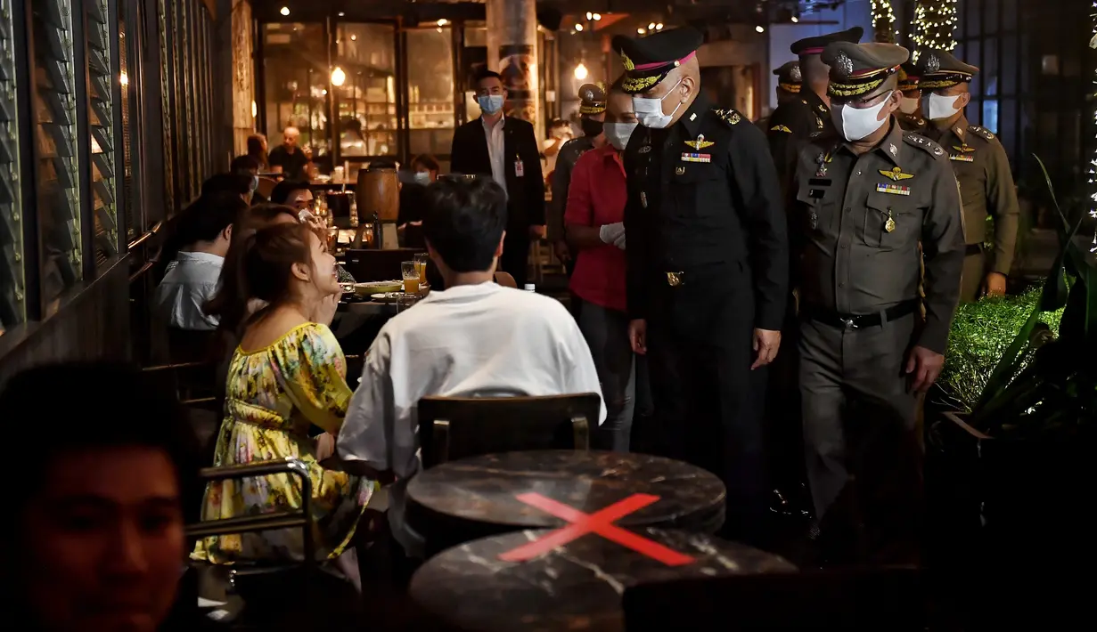Angkatan Bersenjata Kerajaan Thailand Panglima Tertinggi Jenderal Pornpipat Benyasri (tengah) berbicara kepada para pengunjung bar di Bangkok, Thailand, Rabu (1/7/2020). Mulai 1 Juli, bar di Bangkok kembali diizinkan buka setelah pengurangan pembatasan akibat COVID-19. (Lillian SUWANRUMPHA/AFP)