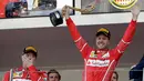 Pembalap Ferrari asal Jerman, Sebastian Vettel mengangkat trofi saat merayakan kemenangannya pada balapan GP Monaco di Sirkuit Monte Carlo, Minggu (28/5). Vettel finis pada urutan pertama dengan waktu satu jam 44 menit 44,340 detik (AP Photo/Claude Paris)
