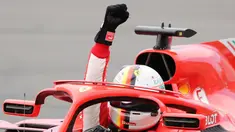 Pembalap Ferrari, Sebastian Vettel mengangkat tangannya saat merayakan kemenangannya di Formula1 Grand Prix (GP) di Montreal, Kanada, Minggu (10/6). Vettel sukses meraih podium juara. (Tom Boland/The Canadian Press via AP)