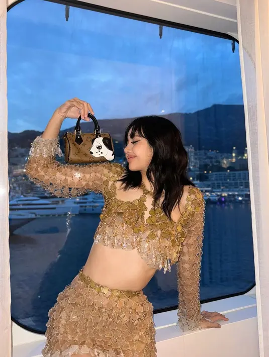 Outfitnya kali ini terdiri dari atasan lengan panjang dengan detail halter-neck dan rok mininya. Outfit ini berhasil menampilkan kaki jenjangnya yang indah dan otot perutnya yang rata. [Foto: Instagram/lalalalisa_m]