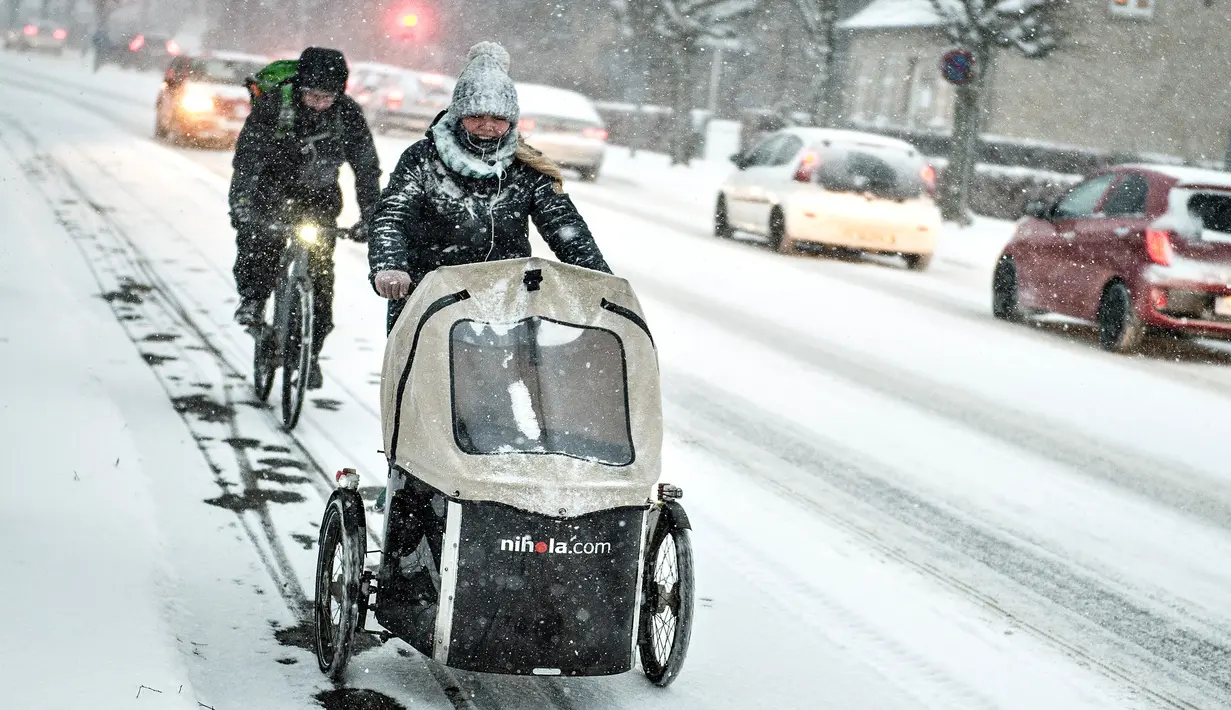 Pengendara sepeda berjuang melewati salju tebal di Aalborg, Denmark, Selasa (27/2). Cuaca dingin di Siberia yang dijuluki "The Beast from the East" membuat suhu di sebagian Eropa menurun. (AFP PHOTO/Scanpix DAN Ritzau SCANPIX/Henning Bagger/Denmark OUT)