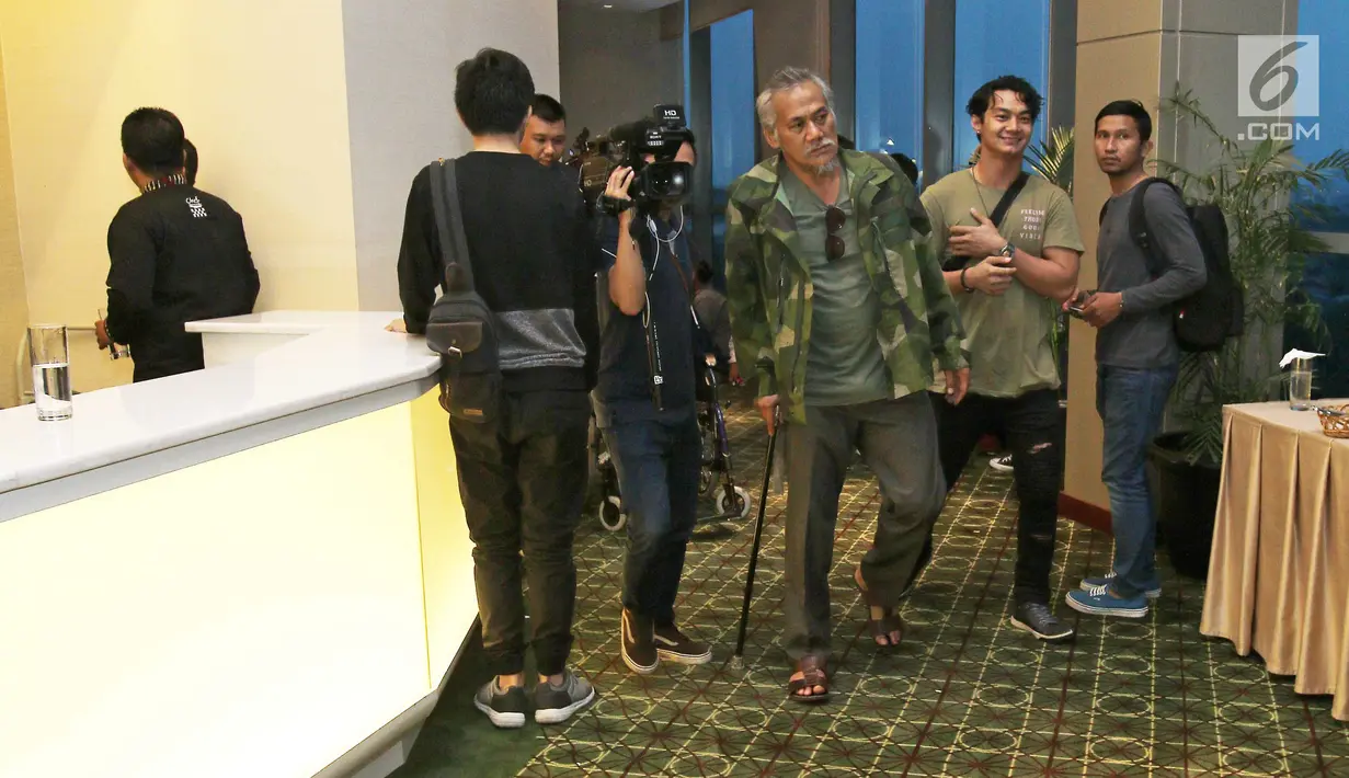 Aktor Tio Pakusadewo berjalan menggunakan tongkat usai mengalami kecelakaan, Jakarta, Rabu (11/10). Akibat kecelakaan tersebut, Tio Pakusadewo harus mendapatkan beberapa jahitan dan mengalami patah tulang. (Liputan6.com/Herman Zakharia)