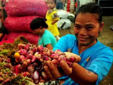 Seorang pedagang menunjukkan bawang merah di Pasar Induk sayur dan buah, Kramat Jati, Jakarta, Jumat, (13/3/2015). Harga bawang merah di sejumlah pasar menembus Rp 30 ribu per kg atau mengalami kenaikan sekitar Rp 2000-5000/kg. (Liputan6.com/Yoppy Renato)