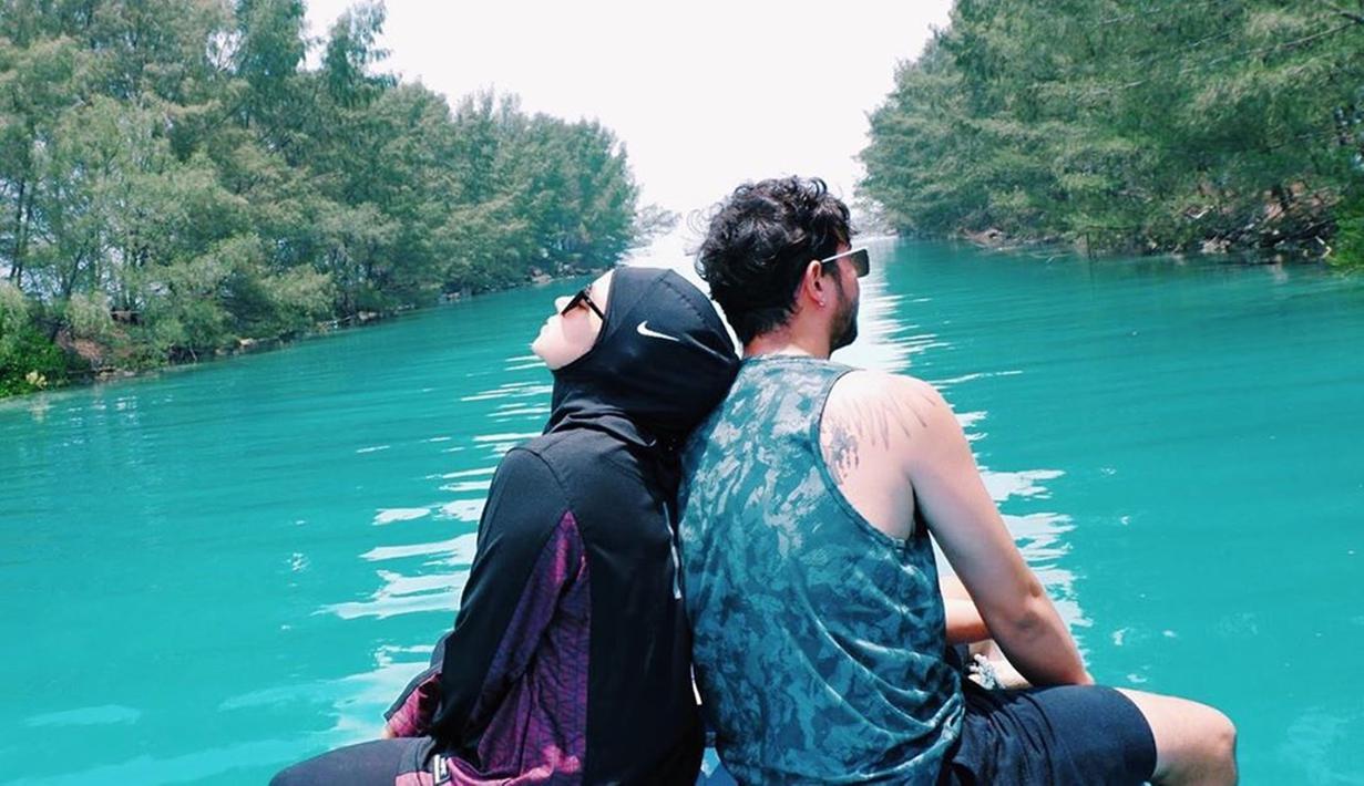 Tak sendiri, traveling Aryani ditemani sang suami Donny Michael. Pasangan yang menikah pada 16 Januari 2016 tampak serasi di atas kapal sambil menikmati pemandangan indah berdua. (Liputan6.com/IG/@aryanifitriana24)