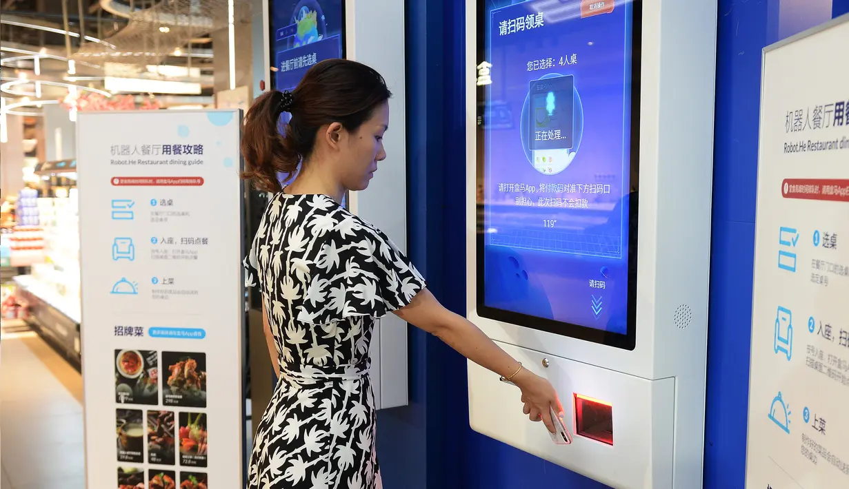 Pengunjung memesan meja dan makanan dengan memindai kode QR lewat smartphone di pintu masuk restoran Robot.He milik Alibaba di Shanghai, 30 Juli 2018. Penggunaan aplikasi bertujuan mengurangi antrean panjang pelanggan yang lapar. (AFP)