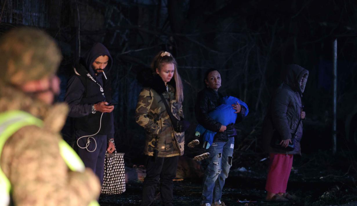 Untuk diketahui, Zaporizhzhia merupakan kota di mana pembangkit listrik tenaga nuklir (PLTN) berada. PLTN Zaporizhzhia, yang terbesar di Eropa, telah diduduki oleh pasukan Rusia sejak Maret 2022. Tampak dalam foto, seorang perempuan (tengah kanan) menggendong anaknya di depan bangunan tempat tinggal yang terbakar setelah serangan Rusia di Zaporizhzhia, Ukraina, Rabu 26 November 2025. (AP Photo/Kateryna Klochko)