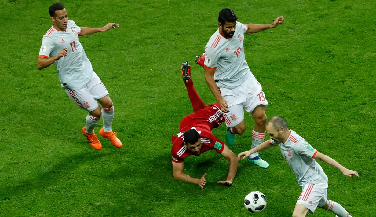 Pemain Iran, Mehdi Taremi (tengah) berebut bola dengan pemain Spanyol Lucas Vazquez (kiri), Diego Costa (dua kanan), Andres Iniesta (kanan) dalam penyisihan Grup B Piala Dunia 2018 di Kazan Arena, Kazan, Rusia, Rabu (20/6). (AP Photo/Eugene Hoshiko)