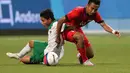 Pemain Indonesia U-23, Evan Dimas Darmono (kiri), berebut bola dengan pemain Singapura U-23, Muhammad Faris Ramli. (Bola.com/Arief Bagus)