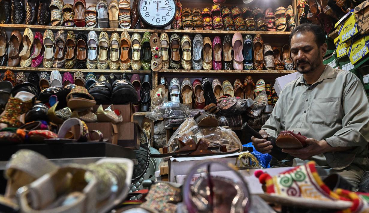 Sepatu datar ini dikenal karena keindahan sulaman benang, manik-manik, atau cermin yang rumit, menjadikannya pilihan utama untuk acara khusus, salah satunya perayaan Idul Fitri. Tampak dalam foto, aktivitas seorang pembuat sepatu membuat khussa, alas kaki tradisional, di sebuah bengkel menjelang perayaan Idul Fitri selama bulan suci Ramadan 1447 Hijriah di Lahore pada 14 Maret 2026. (Arif ALI/AFP)