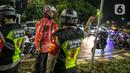 Polisi memberi arahan kepada pengendara motor saat penyekatan jalan di kawasan Pasar Baru, Jakarta, Kamis (31/12/2020). Polda Metro Jaya menutup sejumlah ruas jalan selama Car Free Night dan Crowd Free Night pada malam Tahun Baru 2021 untuk mencegah penyebaran COVID-19. (Liputan6.com/Faizal Fanani)