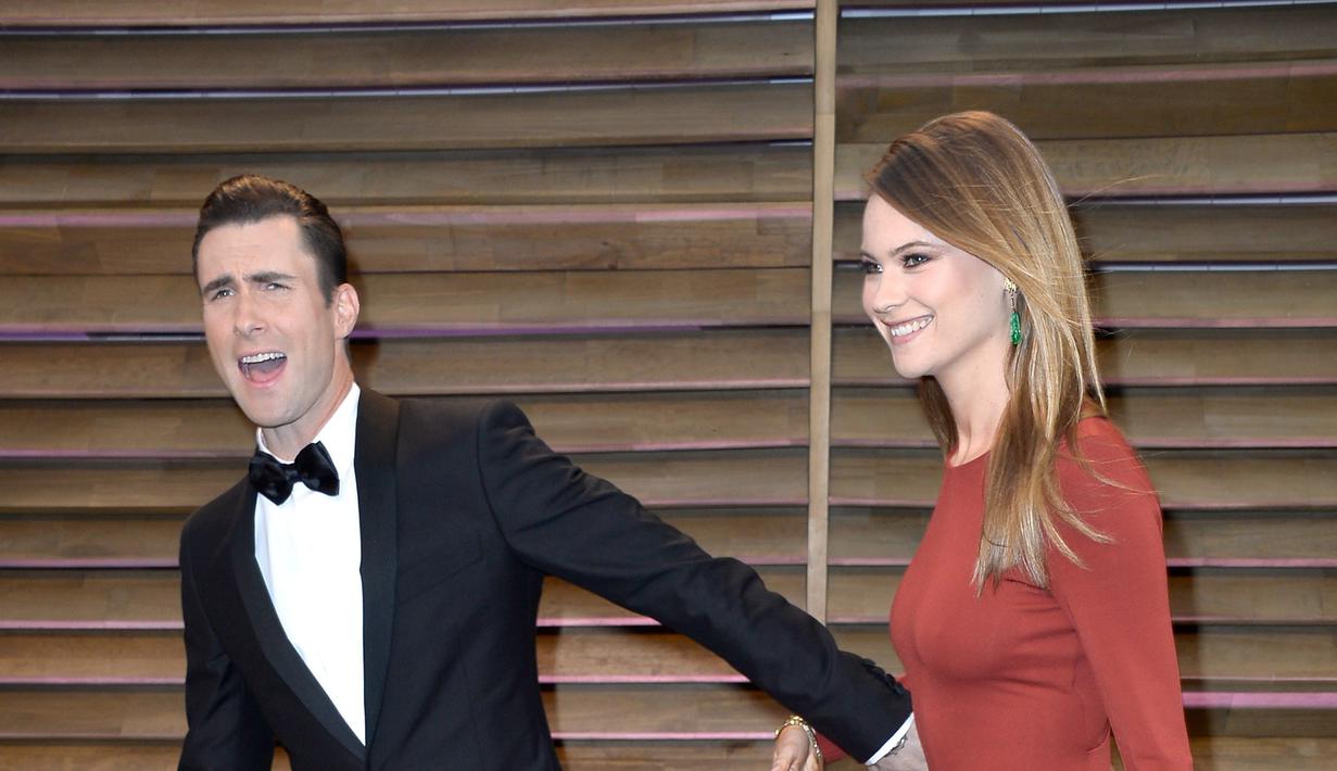 Behati Prinsloo dan Adam Levine menikah di tahun 2014, pada akhir September lalu telah dikaruniai seorang putri cantik bernama Dusty Rose Levine. Bersama keluarga kecilnya, Adam terlihat sedang berlibur di Pantai. (AFP/Bintang.com)
