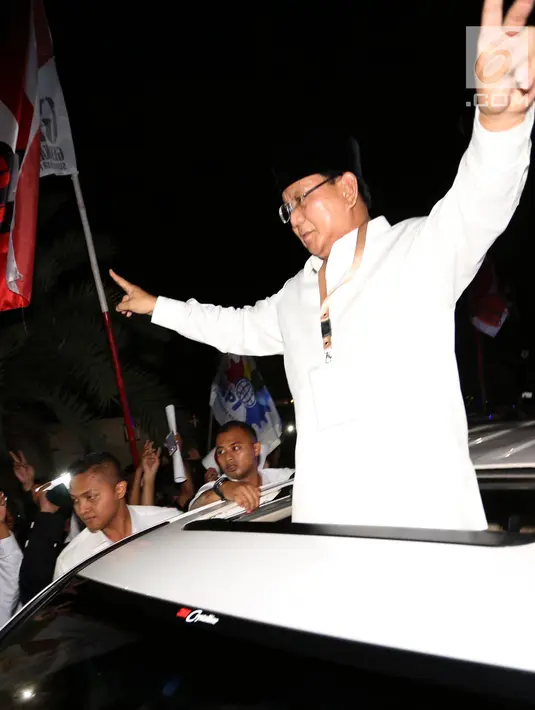 Calon Presiden Prabowo Subianto menyapa pendukungnya di sepanjang jalan Imam Bonjol usai pengambilan nomor urut di Gedung KPU Jakarta, Jumat (21/9). Prabowo memberikan salam 2 jari dengan mobil warna putih. (Liputan6.com/Fery Pradolo)