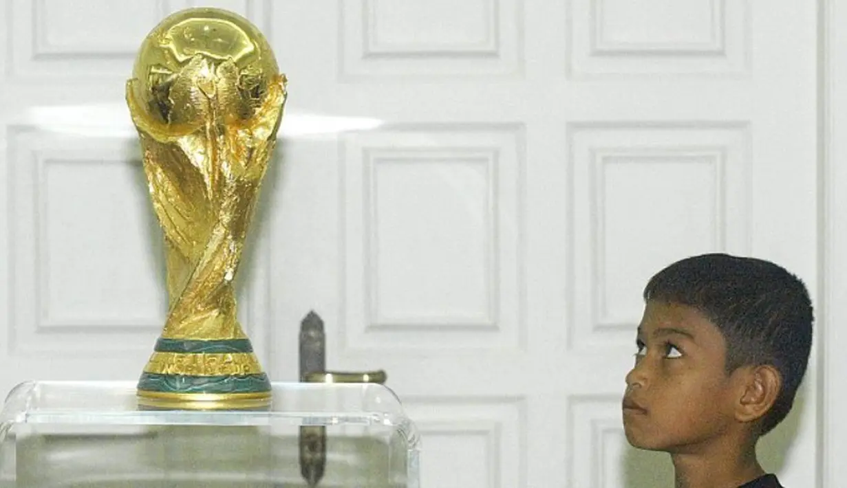 Martunis dengan trofi piala dunia. (Reuters)
