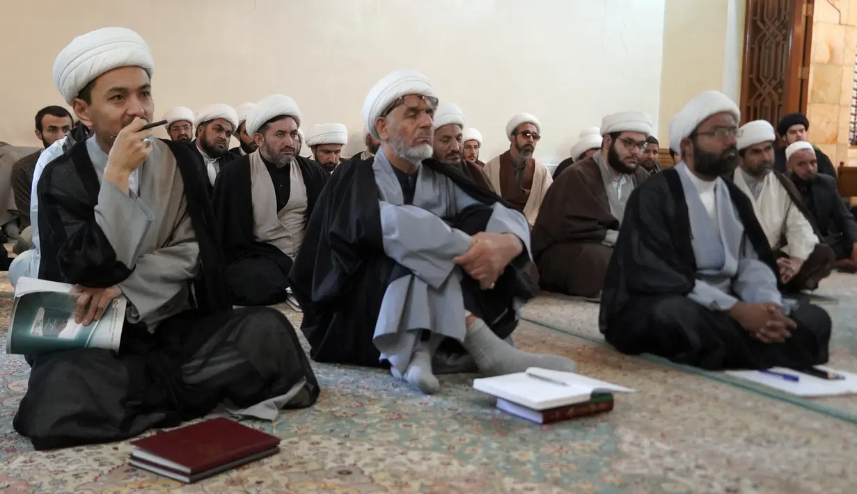 Ulama Syiah mendengarkan guru mereka di kota suci Najaf, Irak, 23 November 2021. Sekolah-sekolah agama di Irak kembali dibuka setelah lebih dari dua tahun di tengah pandemi COVID-19. (Qassem al-KAABI/AFP)