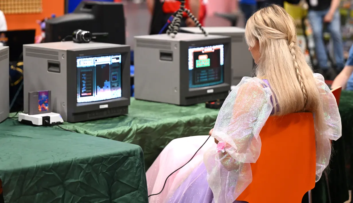 Seorang pengunjung memainkan permainan retro di pameran video game Gamescom di Cologne, Jerman bagian barat pada 23 Agustus 2023. (AFP/Ina Fassbeder)