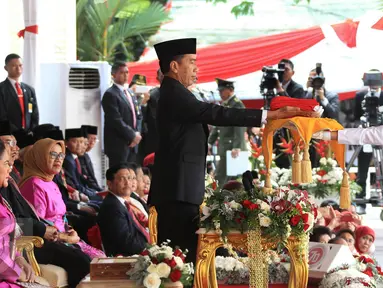 Presiden Jokowi (kiri) menyerahkan bendera Merah Putih kepada anggota Paskibraka Maria Felicia Gunawan saat Upacara Peringatan Detik-detik Proklamasi 17 Agustus di halaman Istana Merdeka, Jakarta, Senin (17/8/2015). (Liputan6.com/Faizal Fanani)