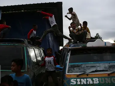 Sejumlah anak terlihat bermain di atas mobil di pengungsian Sinabung, Desa Batu Karang, Medan, Sabtu (4/7/2015). Sebanyak 1254 jiwa dari desa Gursinayan sudah mengungsi selama 1 bulan. (Liputan6.com/JohanTallo)