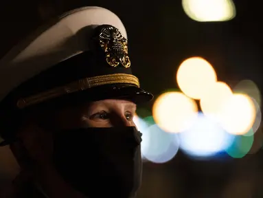 Seorang perwira Angkatan Laut bergabung dalam upacara peletakan karangan bunga di Eternal Light Flagstaff di Madison Square Park, New York pada 11 November 2020. Upacara tersebut diawali dengan Parade Hari Veteran 100 kendaraan, tanpa penonton di Fifth Avenue. (AP Photo/Mark Lennihan)