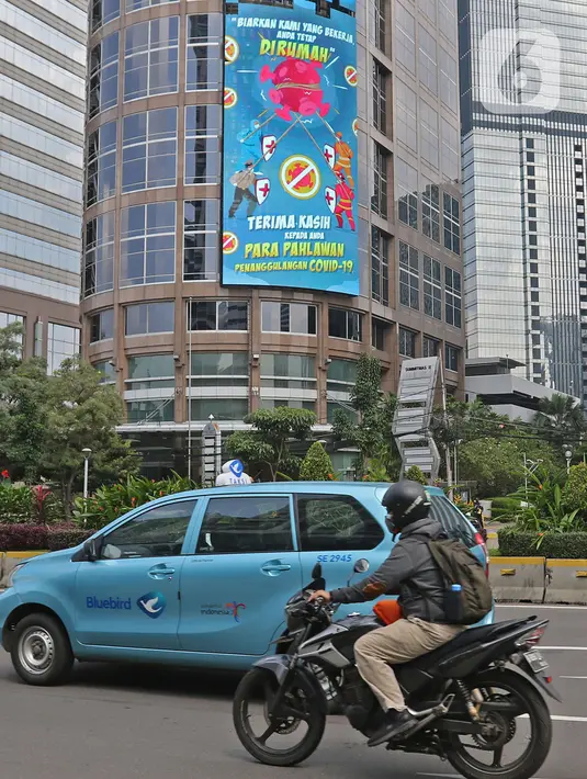 Pengendara motor melintasi Jalan Jenderal Sudirman, Jakarta, Selasa (2/03/2021). Data 21 Februari 2021, DKI Jakarta berhasil keluar dari zona merah Covid-19. Data ini dilaporkan Satuan Tugas Penanganan Covid-19 melalui covid19.go.id, pada Selasa (2/3/2021). (Liputan6.com/Herman Zakharia)