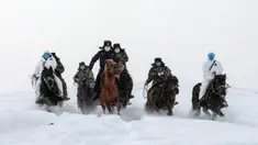 Petugas polisi mengenakan masker wajah berusaha melintasi jalanan bersalju saat akan melakukan sosialisasi tentang bahaya virus COVID-19 sekaligus memeriksa kondisi kesehatan warga daerah terpencil di Altay, Wilayah Xinjiang, China (19/2/2020). (AFP/STR)