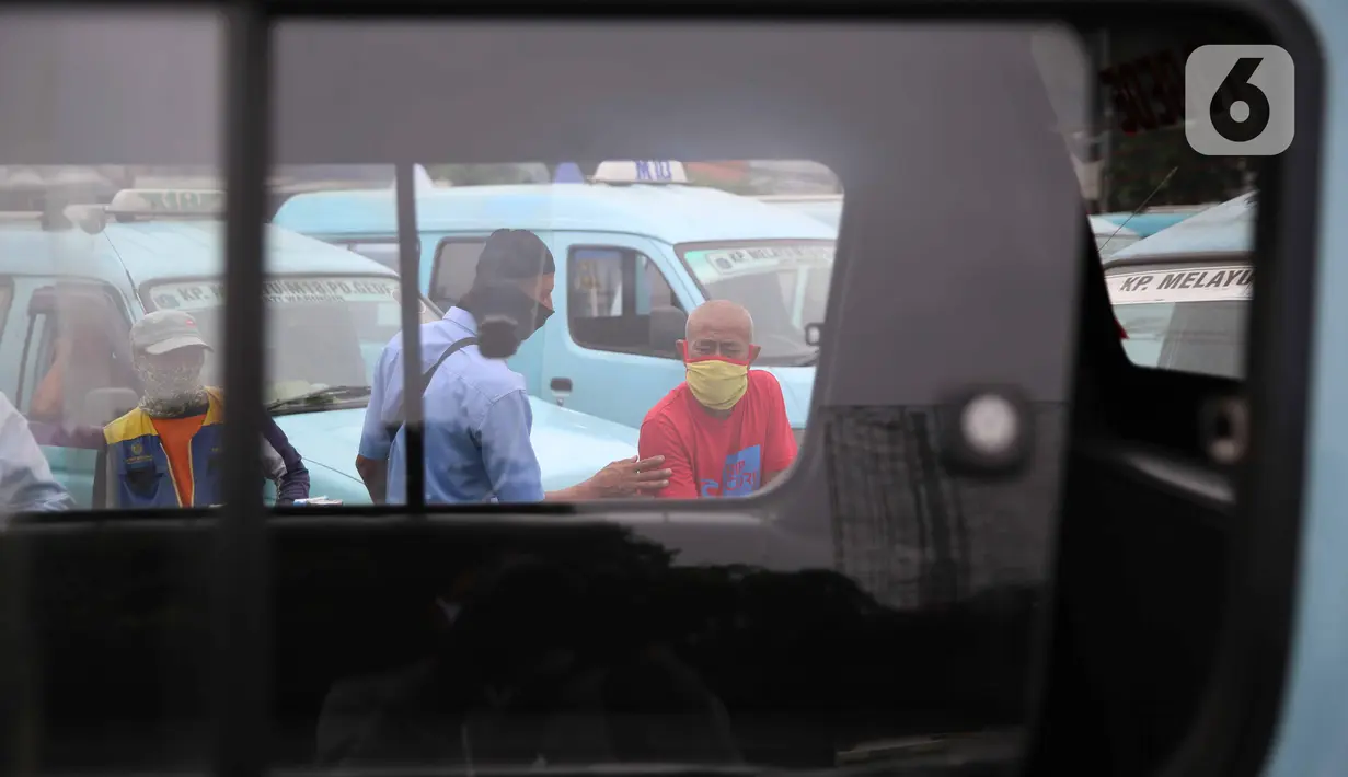 Pengemudi angkutan umum menunggu penumpang di Terminal Kampung Melayu, Jakarta, Kamis (30/4/2020). Menurunnya jumlah angkutan umum yang beroperasi merupakan imbas dari imbauan pemerintah untuk tetap di rumah dan penerapan PSBB sehingga menyebabkan sepinya. (Liputan6.com/Faizal Fanani)