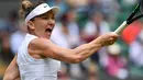 Petenis Rumania, Simona Halep melakukan servis ke arah petenis China, Shuai Zhang pada perempat final Grand Slam Wimbledon di London, Selasa (9/7/2019). Untuk kali pertama dalam lima musim terakhir, unggulan ketujuh Simona Halep akan melakoni babak empat besar di Wimbledon. (GLYN KIRK / AFP)